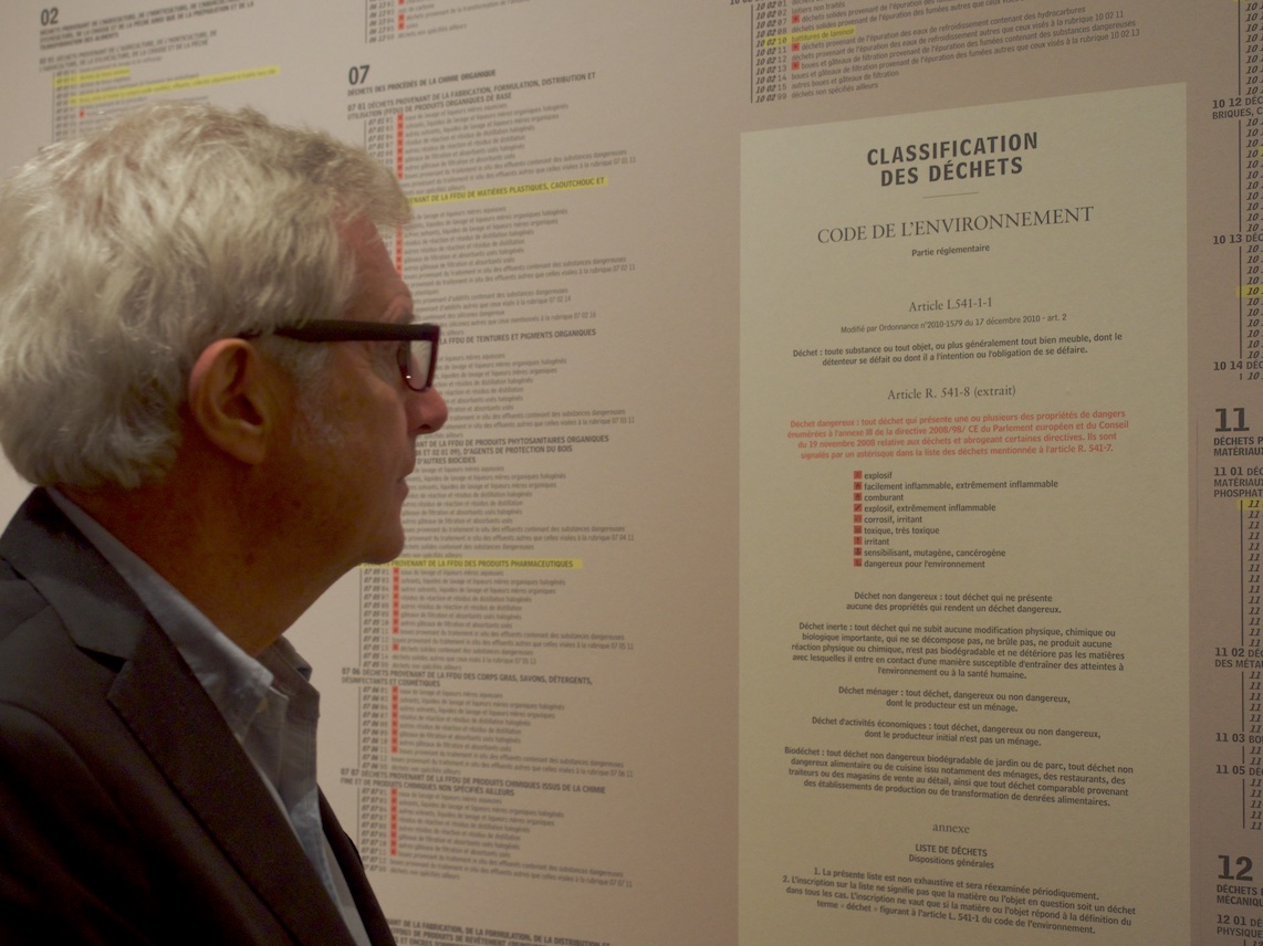 Denis Chevallier, commissaire général d’exposition, devant la nomenclature des déchets — ©Matthieu Duperrex